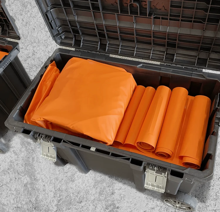 Folded orange Davis fall protection bags packed inside a rolling storage case